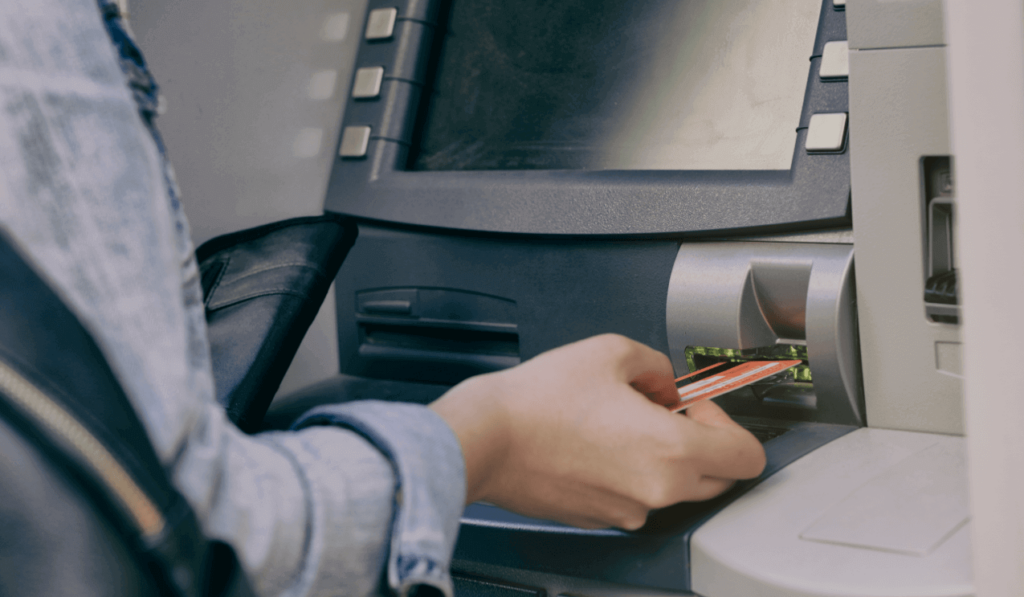 Photograph of hand inserting debit card into ATM